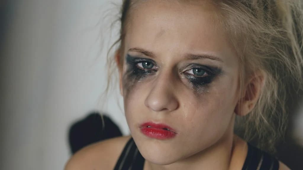 Nærbillede af en ung kvinde der græder med smudset makeup — rå følelse efter skuffelse.