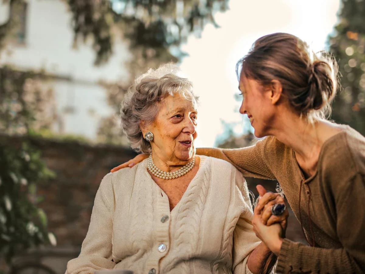 Deux générations souriantes en extérieur, jardin ensoleillé